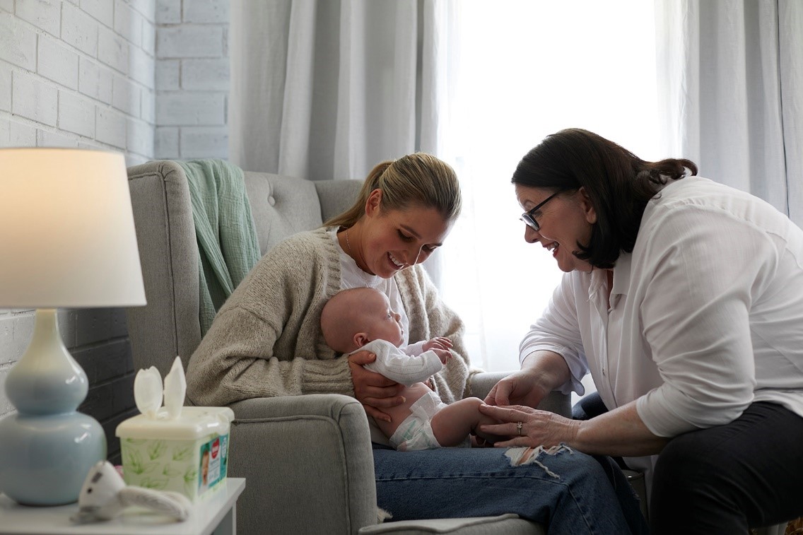 Baby wearing Huggies newborn nappies, playing with Mum and Midwife Cath